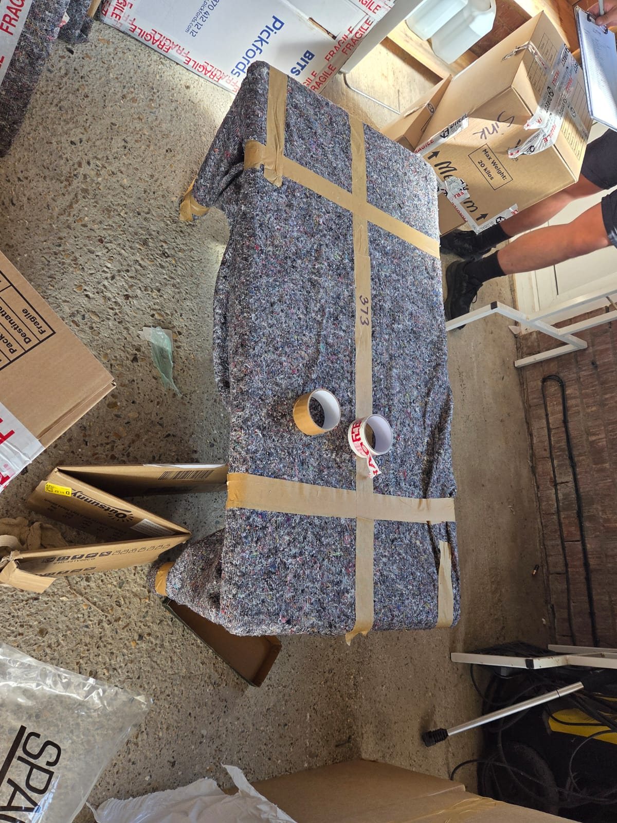 Furniture protected with moving blankets and packing tape.