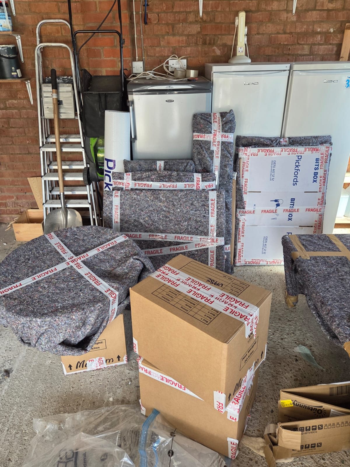 Packed cartons and household items protected with moving blankets.